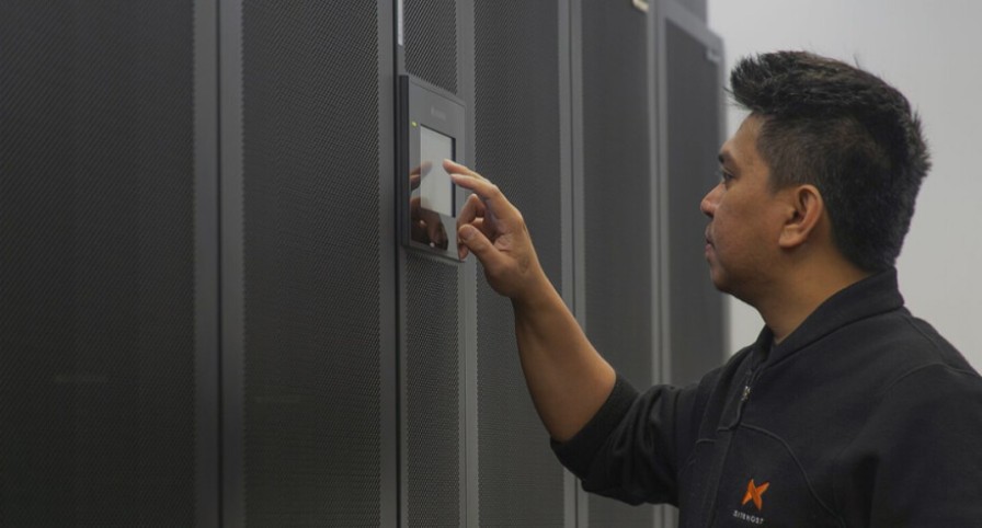 SiteHost team member using data centre touchscreen controls.