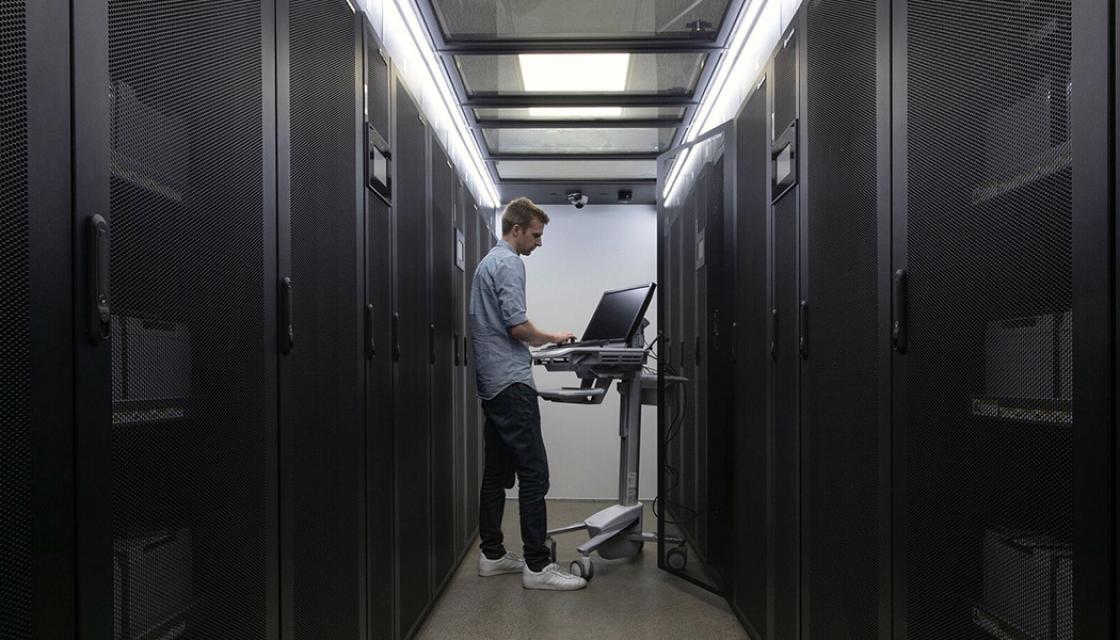 A SiteHost team member working on a laptop inside the SiteHost data centre.